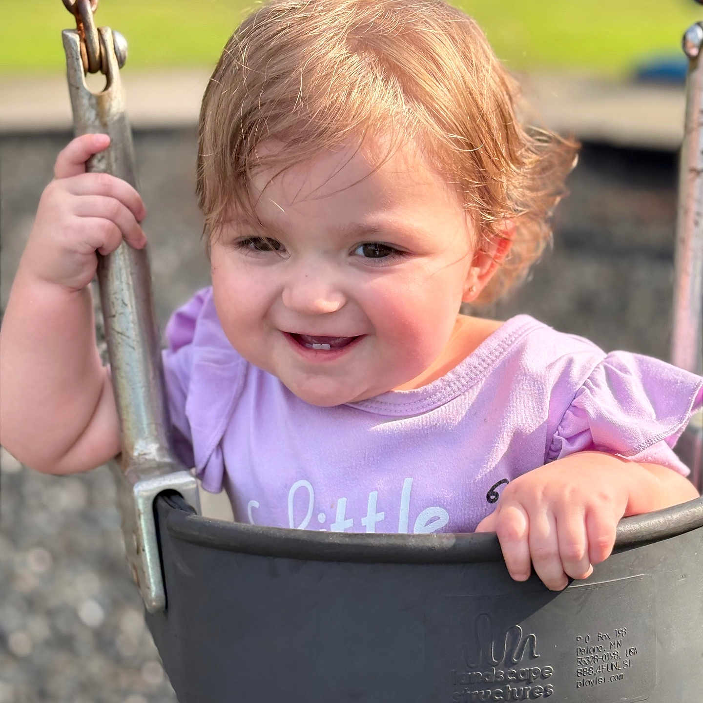 Allison is registered to the contest to win money with this photo: baby, child, cute, daylight, face, fun, grip, hair, happy, metal_chain, outdoor, park, person, playground, purple_clothing, seat, smile, swing, toddler, young_child