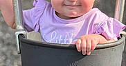 Allison is registered to the contest to win money with this photo: baby, child, clothing, curly_hair, cute, daylight, face, fun, grass, hand, happy, nature, outdoor, person, playground, purple, seat, smiling, swing, toddler