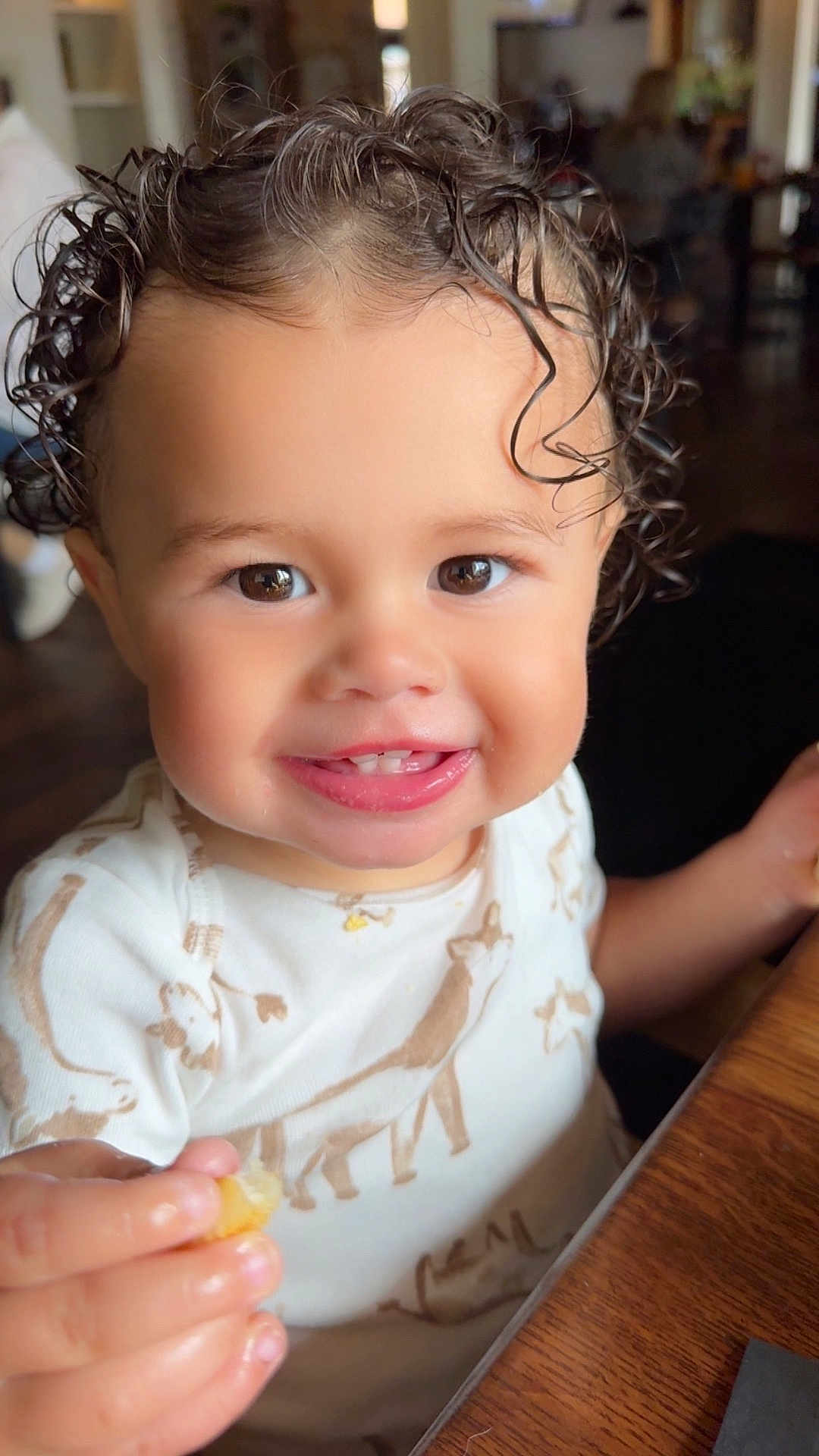 Kolt joined the competition — help win amazing prizes! toddler, child, smiling, curly_hair, brown_eyes, food, hand, onesie, animal_print, indoor, table, wooden_table, face, cute, happy, person, baby, close_up, portrait, eating