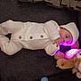 baby, infant, newborn, knit_outfit, white_clothing, beanie, teddy_bear, plush_toy, glowing_light, couch, blanket, buttons, hand, face, eyes, lying_down, indoor, cozy, sleepwear, portrait