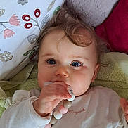 Coleen participe au concours pour gagner de l'argent avec cette photo : baby, child, infant, face, hand, toy, beads, blanket, pillow, curly_hair, blue_eyes, clothing, lying_down, indoor, closeup, cute, soft_texture, playful, relaxed, young