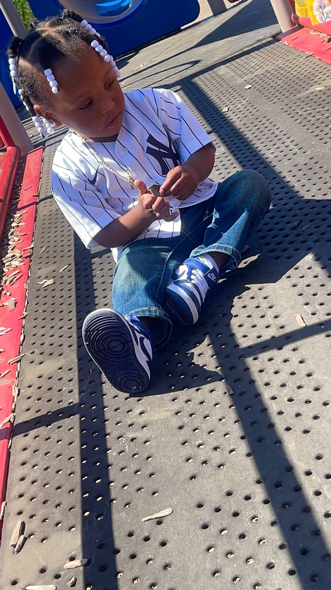 Asriel joined the competition — help win amazing prizes! asphalt, black, city, denim, electric_blue, flooring, hat, human_leg, leisure, light, pattern, person, road_surface, shadow, shoe, sidewalk, sitting, sneakers, thigh, toddler