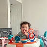Dasean joined the competition — help win amazing prizes! toddler, child, walker, toy, indoor, smiling, happy, person, playtime, furniture, door, floor, baby, curly_hair, plastic, seat, footwear, home, activity, infant