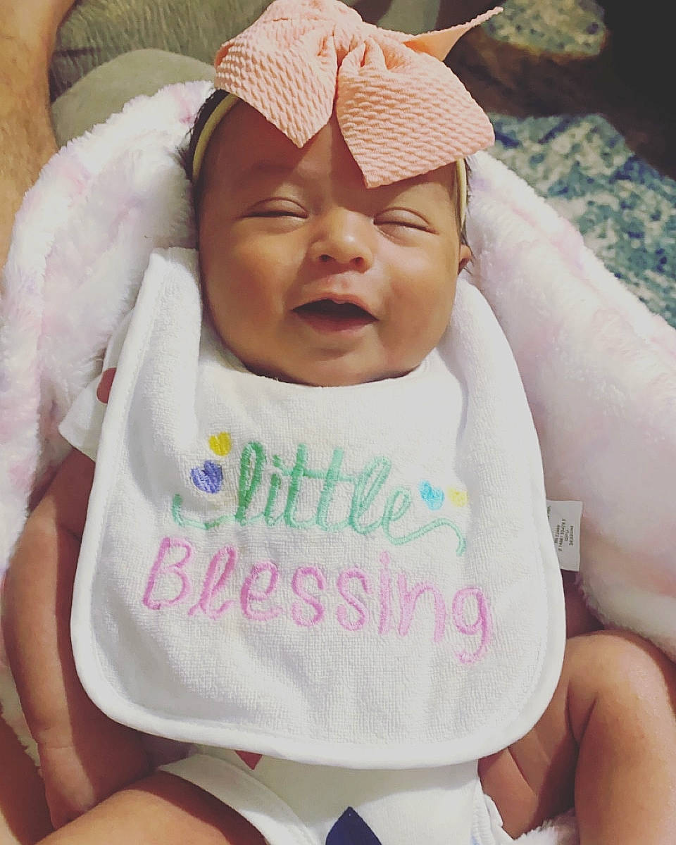 Ava is registered to the contest to win money with this photo: baby, baby_sleeping, baby_toddler_clothing, cheek, comfort, face, facial_expression, finger, happy, head, headwear, lip, mouth, neck, nose, person, pink, skin, sleeve, smile