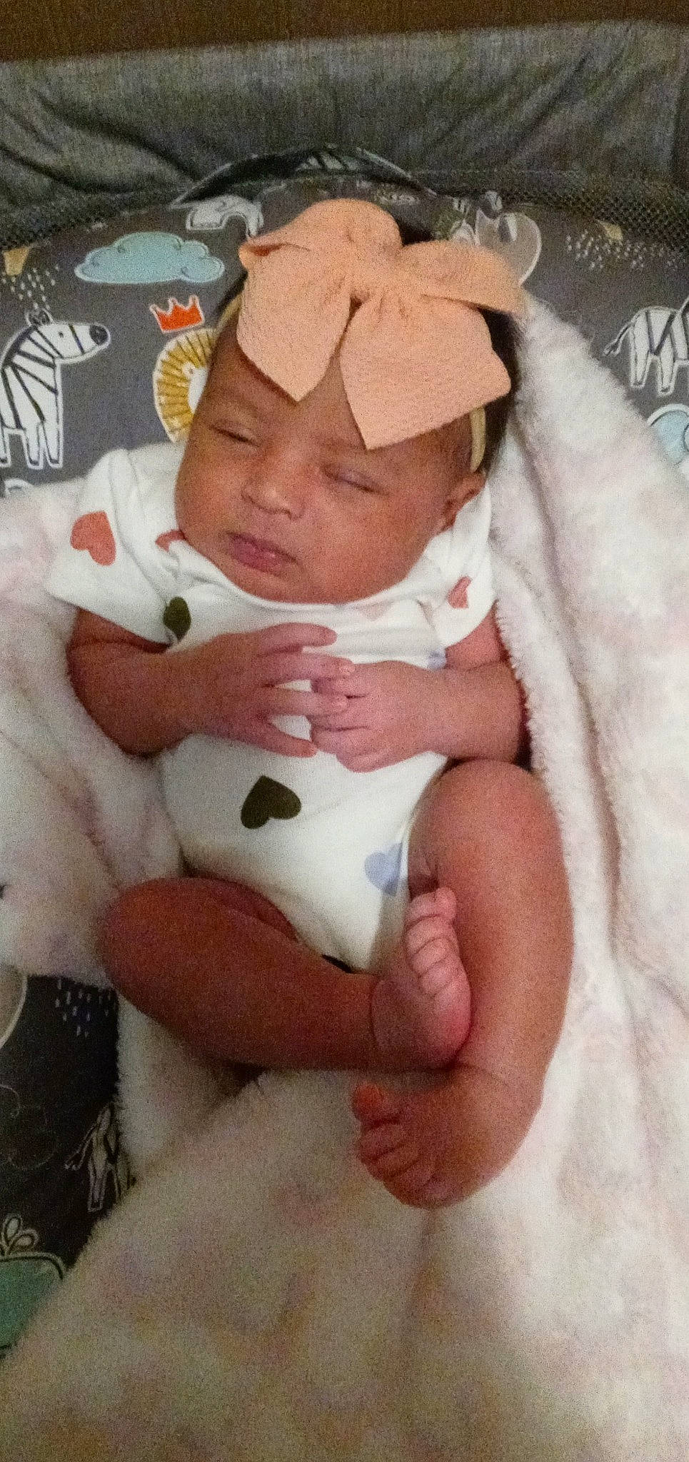 Ava is registered to the contest to win money with this photo: abdomen, baby, baby_products, baby_sleeping, baby_toddler_clothing, cheek, child, comfort, eye, fur, hat, headwear, linens, nail, person, pink, room, sitting, skin, sleeve