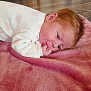 Lyanna participe au concours pour gagner de l'argent avec cette photo : baby, infant, child, onesie, pink_blanket, heart_pattern, lying_down, floor, indoors, red_hair, sucking_thumb, cute, soft_texture, sleepy, toddler, face, skin, head, person, cozy