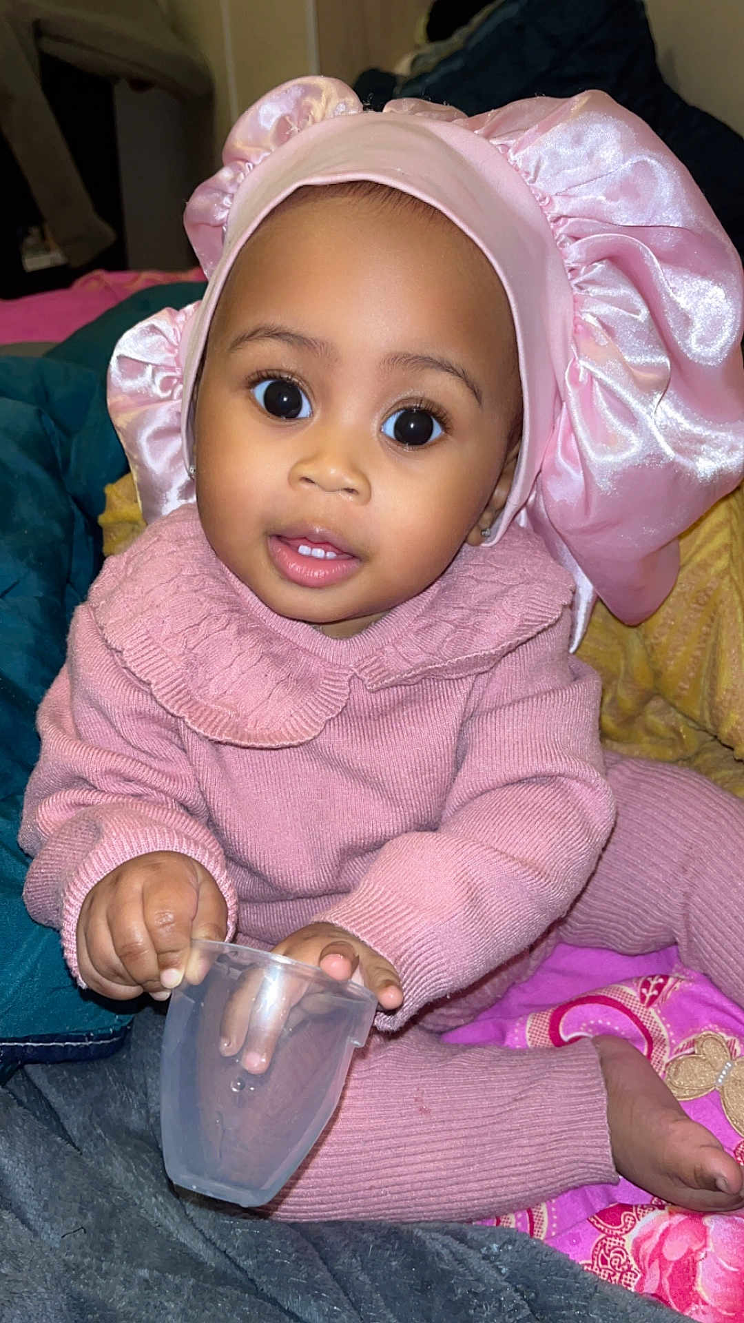 Orlane participe au concours pour gagner de l'argent avec cette photo : toddler, child, pink_clothing, bonnet, knitwear, cup, sitting, indoors, blanket, curious, face, hands, feet, young_child, portrait, cute, cozy, soft_fabric, playing, baby