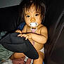 baby, pacifier, hat, couch, blanket, child, indoor, infant, person, cute, skin, hair, holding, sitting, toy, comfort, face, expression, clothing, young