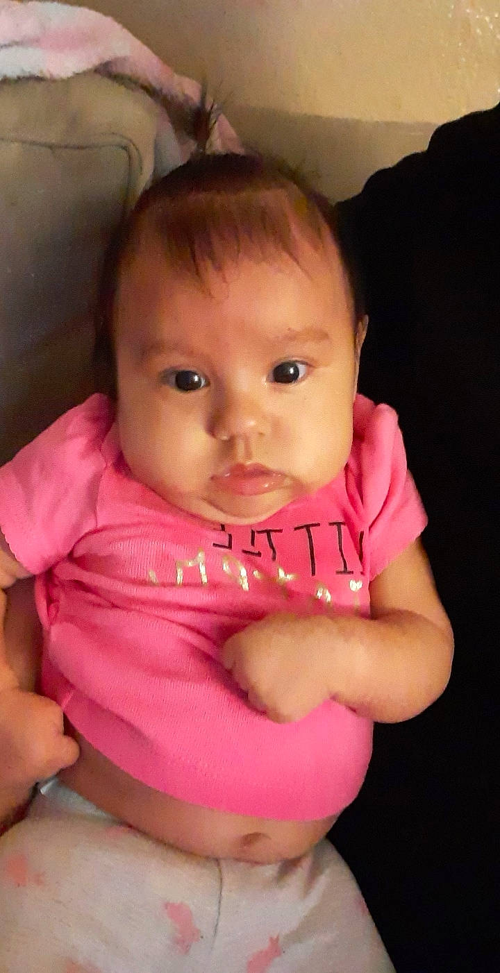 Amara is registered to the contest to win money with this photo: abdomen, baby_toddler_clothing, bib, cheek, child, chin, eyelash, forehead, human, iris, lip, mouth, nail, neck, peach, person, pink, skin, stomach, toddler