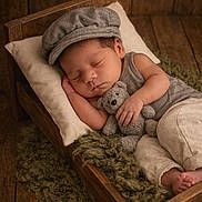 Aiden joined the competition — help win amazing prizes! baby, sleeping, teddy_bear, wooden_bed, cap, pillow, blanket, neutral_clothing, peaceful, infant, cute, cozy, wooden_floor, portrait, child, indoors, resting, soft_light, newborn, small_bed