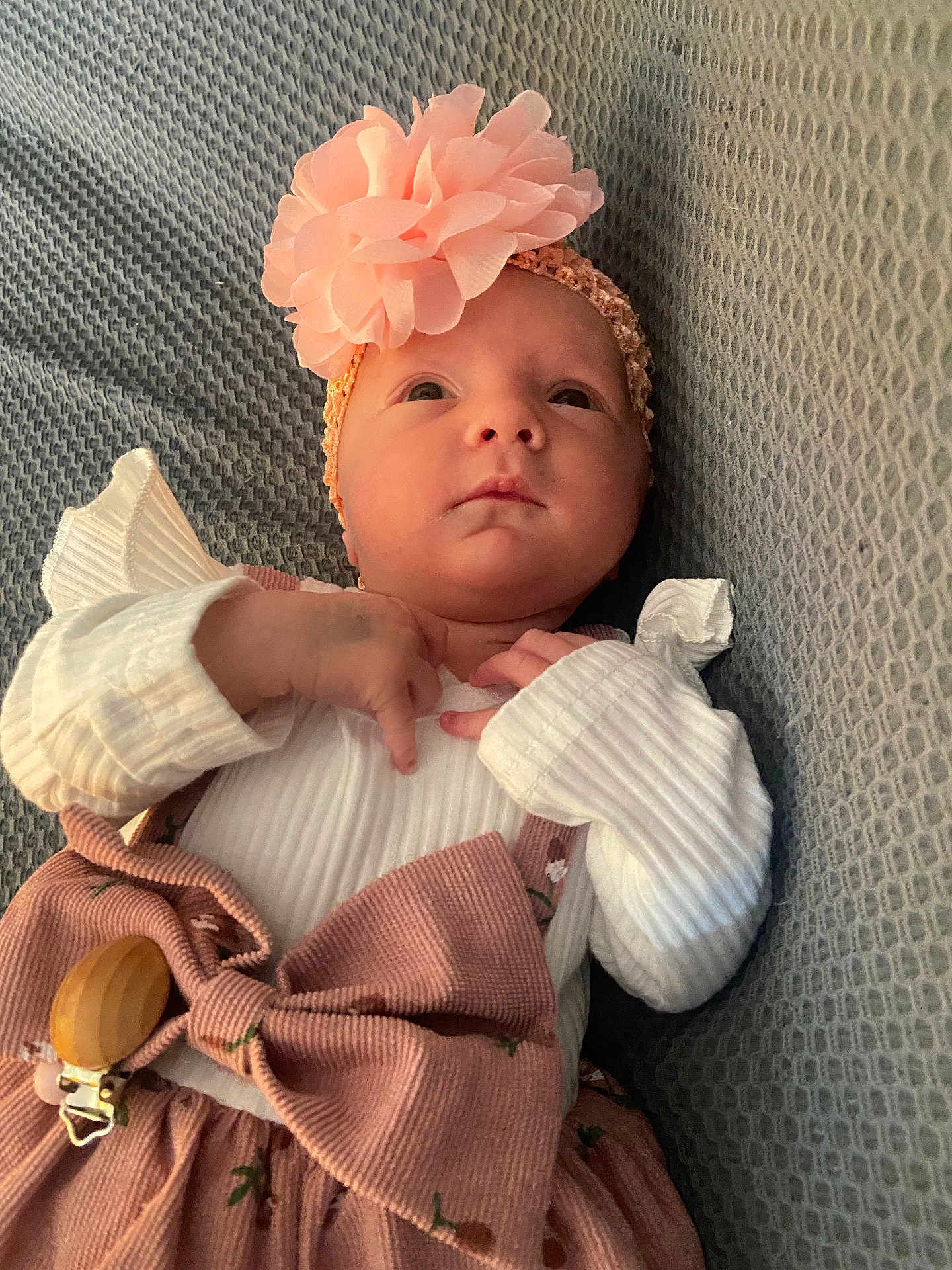 Leonie a rejoint le concours — aidez-le/la à gagner de superbes lots ! baby, infant, headband, flower, bow, pink_clothing, white_shirt, ribbed_fabric, blanket, textured, lying_down, cute, portrait, newborn, small_hands, indoor, soft_lighting, curious_expression, child, peaceful