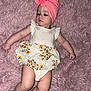 baby, infant, child, pink, towel, headwear, dress, floral, pattern, laying, rug, soft_texture, cute, calm, skin, legs, arms, indoors, portrait, clothing