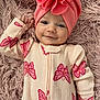 Mariana is registered to the contest to win money with this photo: baby, infant, smile, pink_headwrap, butterfly_pattern, onesie, soft_rug, cozy, cute, child, laying_down, portrait, happy, fabric_texture, baby_clothing, headwear, indoor, closeup, baby_face, newborn