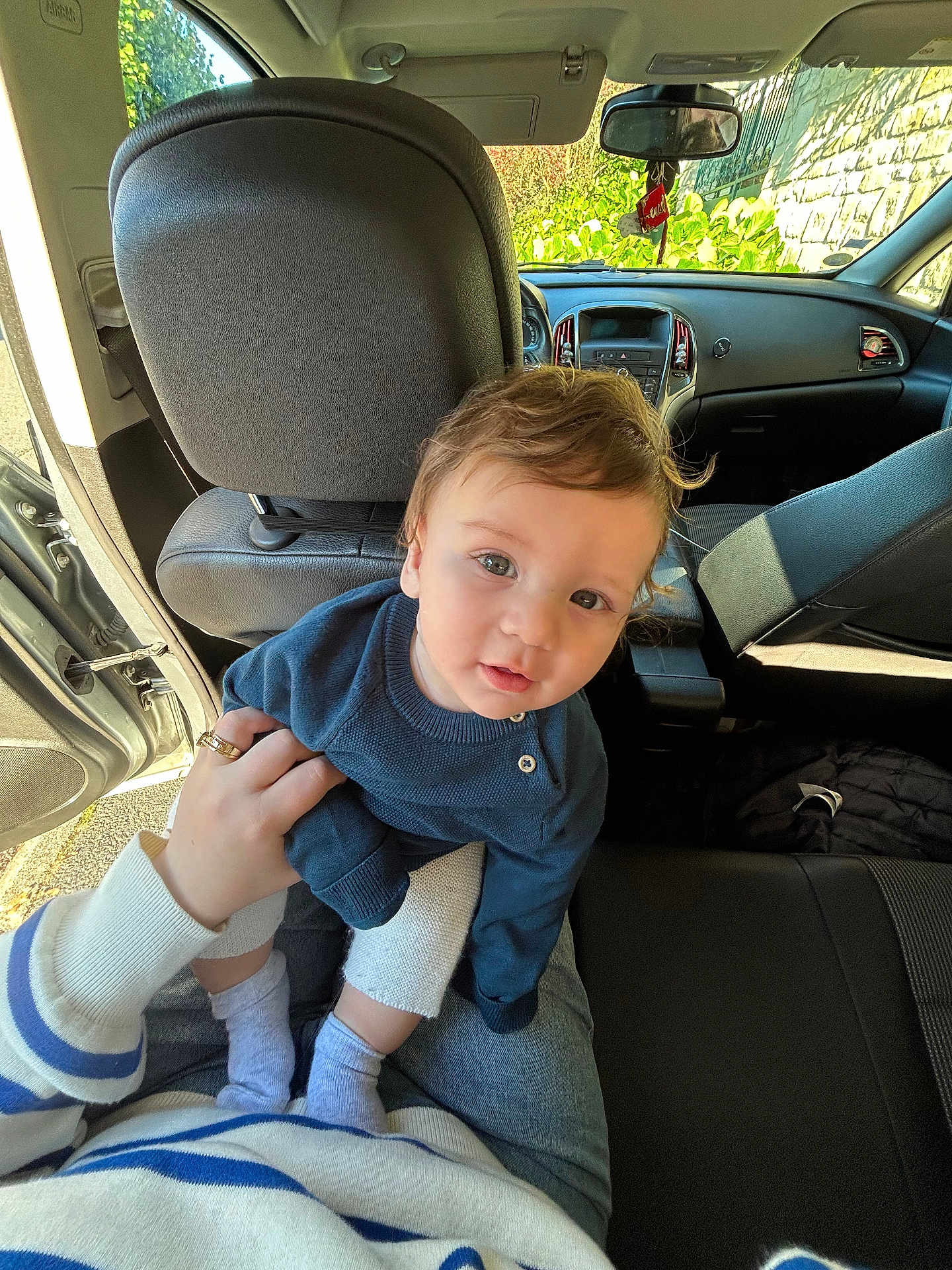 Enis participe au concours pour gagner de l'argent avec cette photo : baby, child, car_interior, blue_sweater, person, lap, hand, curly_hair, seat, sunlight, open_car_door, casual_clothing, indoor, portrait, cute, young_child, socks, human, looking_at_camera, seated