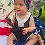Quinn joined the competition — help win amazing prizes! baby, child, sitting, sunglasses, headwrap, romper, towel, umbrella, newspaper_print, grass, barefoot, outdoor, cute, playful, summer, colorful, star_pattern, portrait, infant, accessory