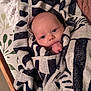 baby, infant, towel, striped_towel, wrapped, blue_eyes, curious, cozy, soft_texture, blanket, bed, sleeping_area, child, person, cute, small_hand, skin, head, portrait, indoor