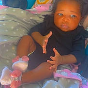 Ja'Nya is registered to the contest to win money with this photo: baby, infant, child, black_clothing, headband, bow, blanket, polka_dot, pink, white, booties, feet, hands, lying_down, indoors, cute, portrait, soft_texture, cozy, young_child
