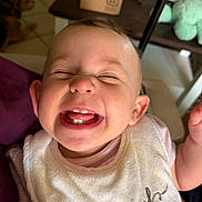 Maclyn is registered to the contest to win money with this photo: baby, smiling, teeth, bib, indoor, person, happy, child, face, head, hand, furniture, dog, shelf, floor, clothing, closeup, expression, joy, home