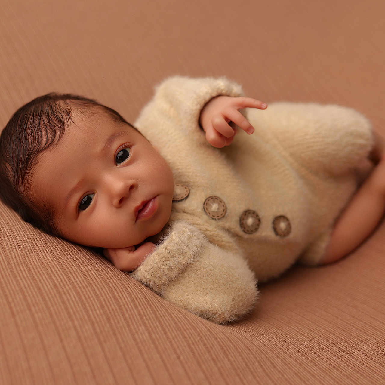 Tiago a rejoint le concours — aidez-le/la à gagner de superbes lots ! baby, brown_background, buttons, child, close_up, cozy, curious, cute, face, hand, infant, laying_down, newborn, portrait, relaxed, skin, soft_light, soft_texture, sweater, warm_tones