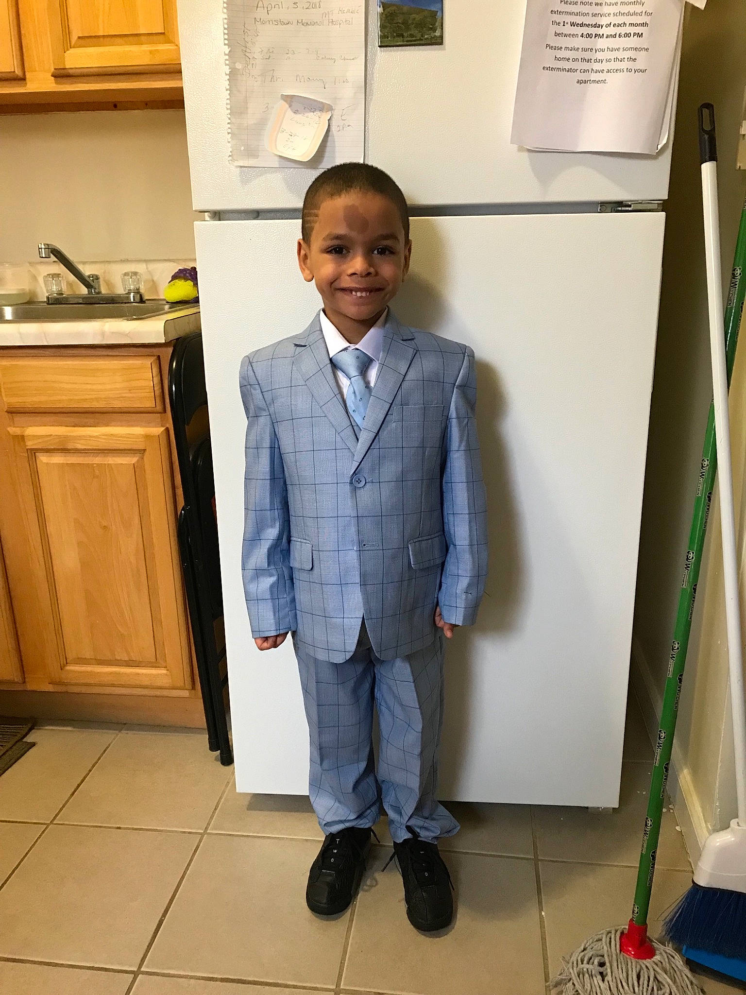 Davion is registered to the contest to win money with this photo: child, formal_wear, jeans, joy, outerwear, person, room, shoe, standing, suit, tie