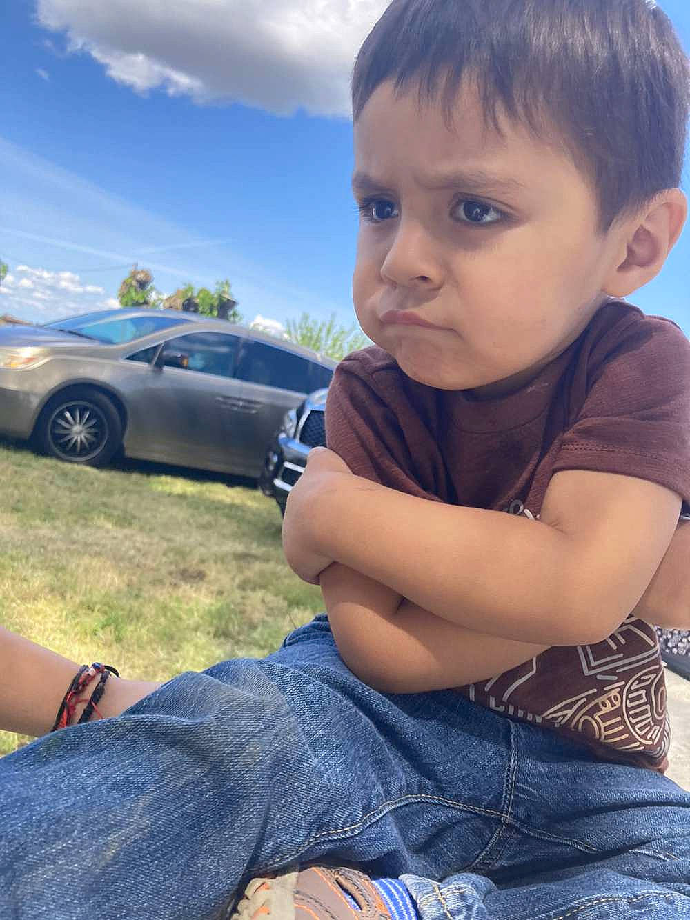 Jared is registered to the contest to win money with this photo: automotive_design, automotive_lighting, automotive_tire, car, cool, facial_expression, finger, grass, hand, happy, jeans, morning, motor_vehicle, person, plant, sky, sunlight, tire, toddler, vehicle_door