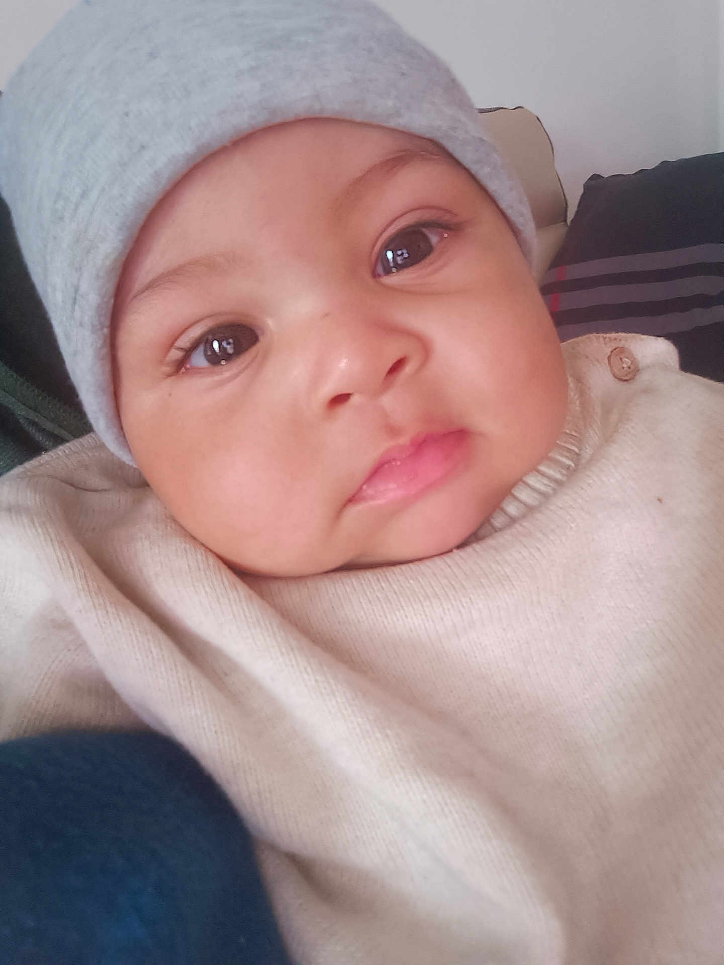 Ethan Maëron participe au concours pour gagner de l'argent avec cette photo : baby, infant, child, face, eyes, beanie, hat, cheeks, lips, sweater, button, close_up, portrait, adorable, indoor, pillow, blanket, gaze, rosy_cheeks, newborn