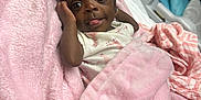Taisley joined the competition — help win amazing prizes! baby, infant, blanket, pink, headband, bow, cute, tongue, face, indoors, hospital_bed, soft_texture, child, newborn, wrapped, adorable, person, lying_down, cozy, young