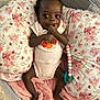 Taisley joined the competition — help win amazing prizes! baby, infant, child, blanket, pillow, floral_pattern, pacifier, beads, hand, foot, onesie, pink, soft_texture, mesh_side, cute, lying_down, indoors, comfort, sleeping_area, young_child