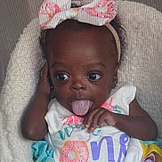 Taisley joined the competition — help win amazing prizes! baby, child, infant, tongue_out, headband, bow, pink, donut, colorful_clothing, first_birthday, cute, playful, smiling, portrait, soft_texture, fluffy, happy, young_child, person, indoors