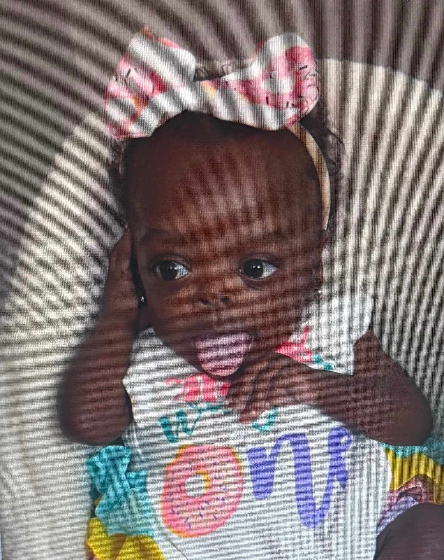 Taisley joined the competition — help win amazing prizes! baby, child, infant, tongue_out, headband, bow, pink, donut, colorful_clothing, first_birthday, cute, playful, smiling, portrait, soft_texture, fluffy, happy, young_child, person, indoors