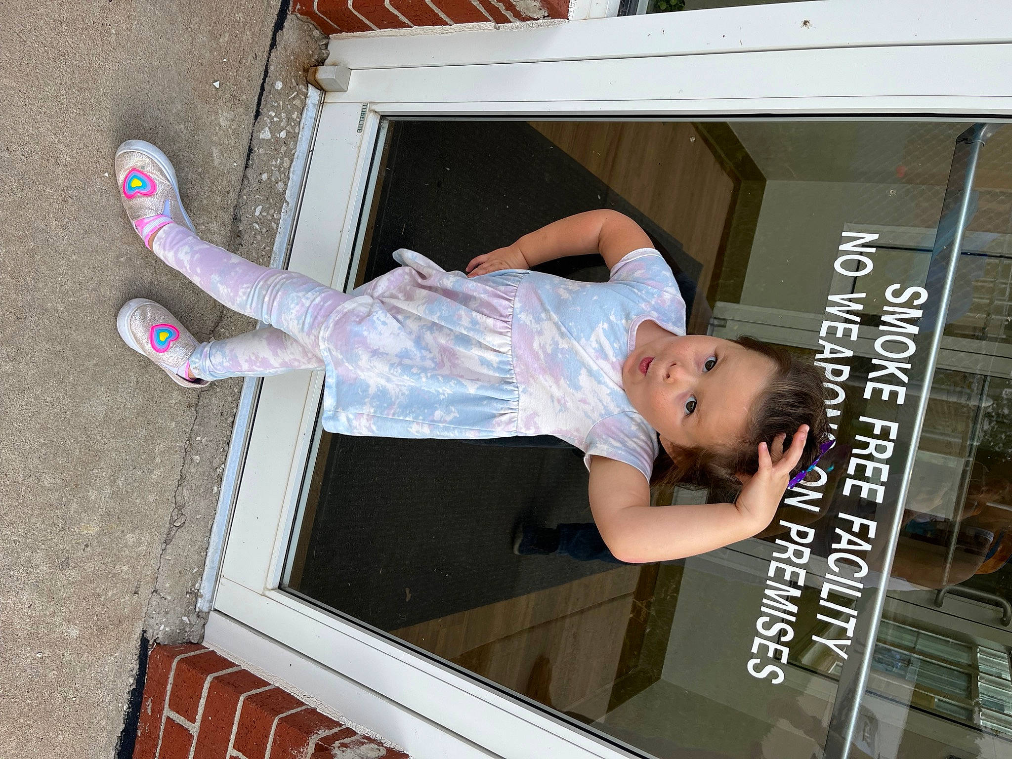 Pearl is registered to the contest to win money with this photo: advertising, baby, baby_toddler_clothing, child, display_device, font, fun, human_leg, person, sandal, surprise, t_shirt, thigh, toddler, window