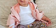 Bernadette is registered to the contest to win money with this photo: toddler, child, baby, sitting, blanket, pillow, floral_leggings, pink_jacket, white_shirt, black_boots, indoor, home, cute, smiling, face, person, cozy, soft_texture, comfort, portrait