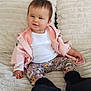toddler, child, baby, sitting, blanket, pillow, floral_leggings, pink_jacket, white_shirt, black_boots, indoor, home, cute, smiling, face, person, cozy, soft_texture, comfort, portrait