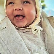 Beatrice participe au concours pour gagner de l'argent avec cette photo : baby, infant, smiling, laughing, tongue_out, bonnet, hood, coat, sweater, dress, closeup, portrait, rosy_cheeks, chubby_cheeks, adorable, happy, earring, fabric_texture, soft_lighting, warm_clothing