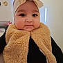 baby, infant, headband, bow, fur_scarf, scarf, closeup, portrait, indoors, cute, chubby_cheeks, earring, eyes, smile, warm_clothing, soft_texture, wall, soft_lighting, person, fashion