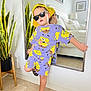 bedroom, black_sunglasses, casual, child, decor, fashion, fun, home, indoor, kid, mirror, plant, posing, purple_outfit, reflection, sandals, smiling, spongebob_clothing, tile_floor, yellow_cap