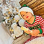 blanket, child, christmas, cozy, cute, decorations, festive, hat, holiday, indoors, lights, pajamas, plush_toy, polar_bear, portrait, sitting, striped_clothing, toy, winter, wood