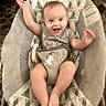 baby, smiling, rocker, infant, happy, arms_up, seated, clothing, patterned_fabric, indoor, cushion, cute, child, face, footwear_none, playful, home, young_child, baby_girl_or_boy, soft_toys