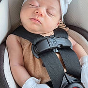 Era Viella is registered to the contest to win money with this photo: baby, bow, car_seat, child, closeup, clothing, comfort, cute, face, headband, infant, mittens, peaceful, red_button, resting, safety, seat, skin, sleeping, straps