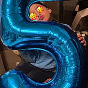 Maëlyo participe au concours pour gagner de l'argent avec cette photo : balloon, blue, casual, celebration, child, clothing, cute, face, fun, hand, home, indoor, kid, number_five, party, playful, pucker, sitting, smile, young