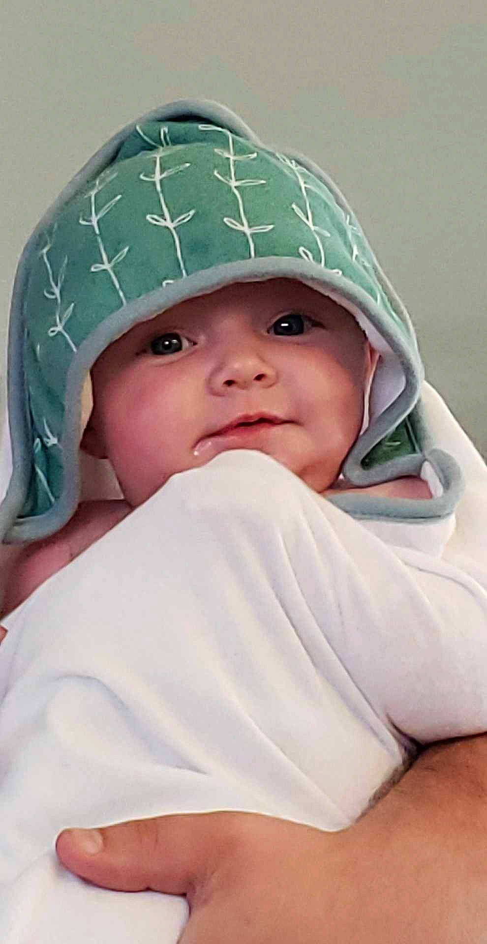 Astrid is registered to the contest to win money with this photo: baby, beanie, bonnet, cap, cheek, child, comfort, eyebrow, fashion_accessory, happy, headgear, headwear, hoodie, knit_cap, linens, person, portrait_photography, skin, sleeve, smile