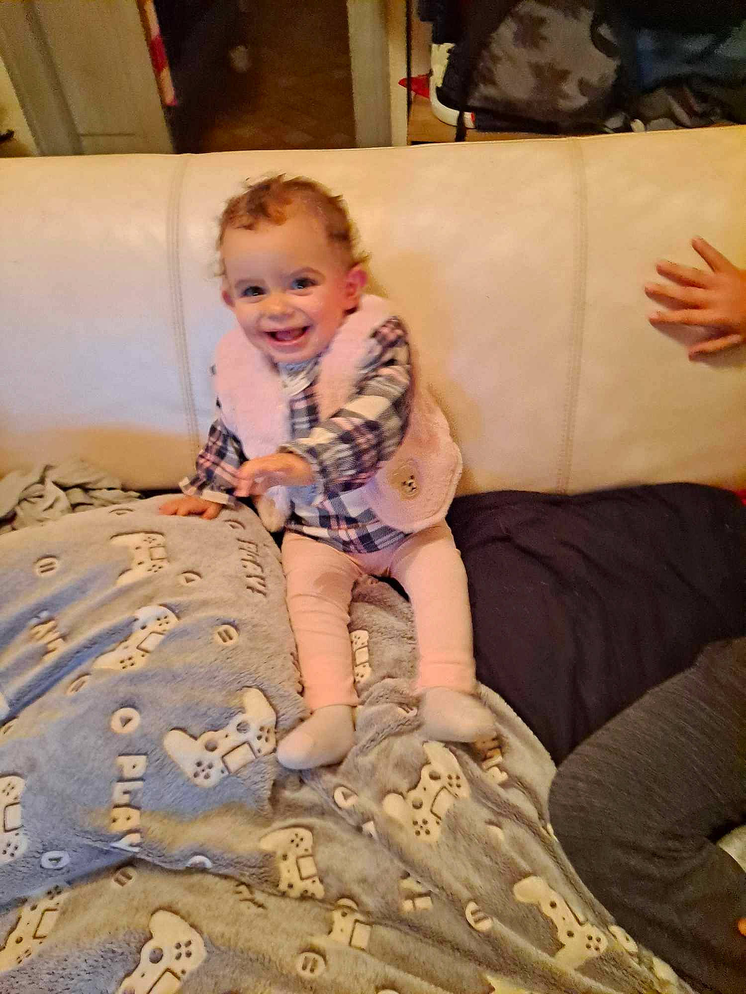 Izia participe au concours pour gagner de l'argent avec cette photo : baby, baby_toddler_clothing, child, comfort, couch, flooring, fun, happy, human_leg, joy, leisure, linens, mammal, pattern, person, room, sitting, skin, smile, thigh