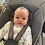 baby, car_seat, child, infant, face, straps, white_clothing, red_hearts, pout, curious_eyes, indoor, seat, safety_harness, person, cute, expression, head, young_child, fabric, soft