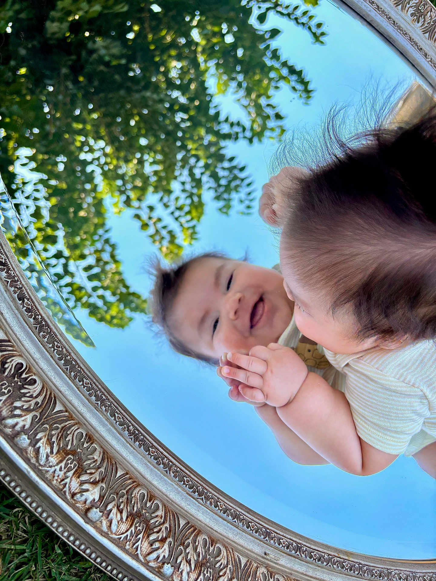 Liam joined the competition — help win amazing prizes! baby, smile, reflection, mirror, outdoor, sky, greenery, grass, face, hands, cute, portrait, nature, child, happy, playful, person, light, daylight, framed
