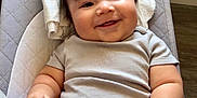 Liam joined the competition — help win amazing prizes! baby, smiling, infant, onesie, baby_seat, cushion, dinosaur_print, clothing, hair, face, hand, straps, happy, indoor, floor, plush, head, skin, person, child
