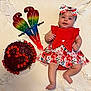 baby, child, infant, red_dress, flower_pattern, headband, smiling, cake, cherries, parrot_decoration, blanket, laying_down, cute, celebration, food, dessert, colorful, happy, indoors, portrait