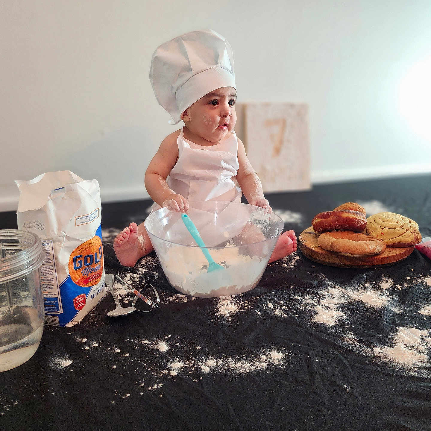 Bodoquito joined the competition — help win amazing prizes! apron, baby, baking, chef_hat, child, cookies, cute, doughnut, flour, food, indoor, kitchen, messy, mixing_bowl, pastries, person, playful, sitting, spoon, table