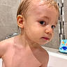 Marceau participe au concours pour gagner de l'argent avec cette photo : toddler, child, bathroom, wet_hair, skin, face, portrait, curious, looking_away, bath_toy, tile_wall, young_child, indoors, head, shoulder, person, cute, expression, water_droplets, naked_torso