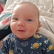 Aydenn participe au concours pour gagner de l'argent avec cette photo : baby, infant, face, smile, blue_eyes, space_theme, clothing, planets, rocket, blanket, towel, indoors, cute, child, portrait, head, young, soft_light, closeup, happy