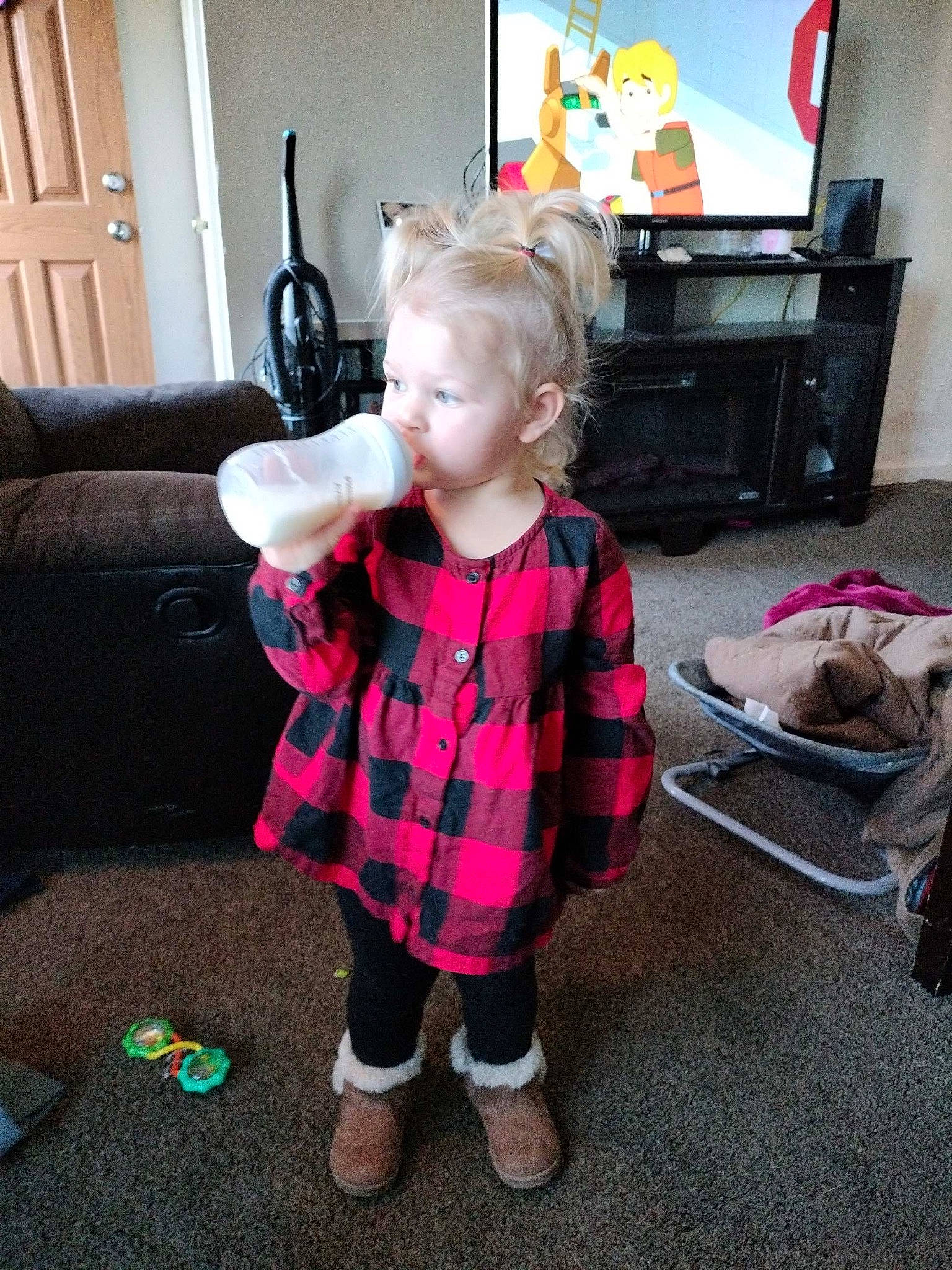 Raelynn joined the competition — help win amazing prizes! baby_toddler_clothing, child, couch, drawer, event, floor, flooring, fun, holiday, living_room, pattern, person, picture_frame, plaid, sitting, sleeve, sock, standing, tartan, television